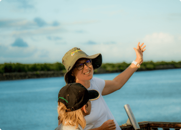 Tour guide enthusiastically sharing information with a visitor by the waterfront, illustrating the personalised experience of a private tour with Anytime Tours.