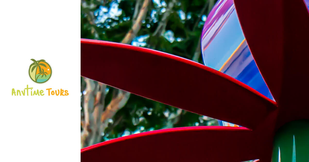 Close-up of a vibrant flower sculpture with green foliage in the background